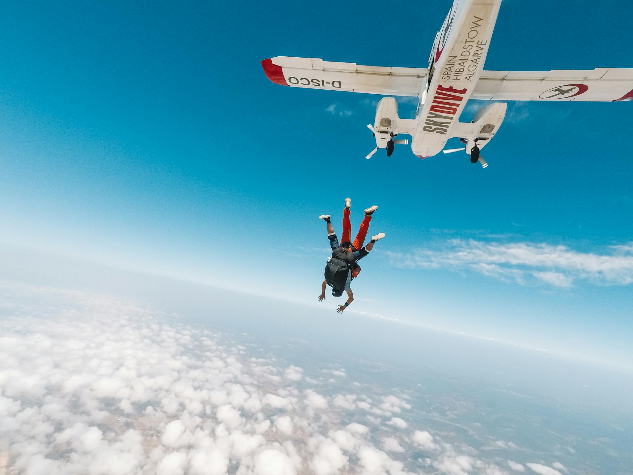 Capture the thrill of tandem skydiving over the breathtaking Algarve skies with a plane in view.