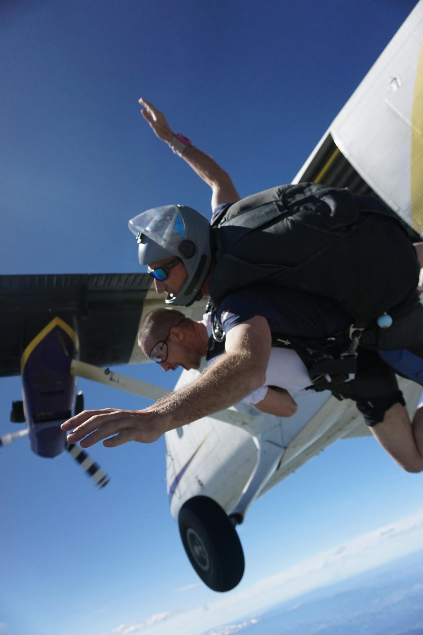 Experience the adrenaline of tandem skydiving from a plane with clear blue skies.