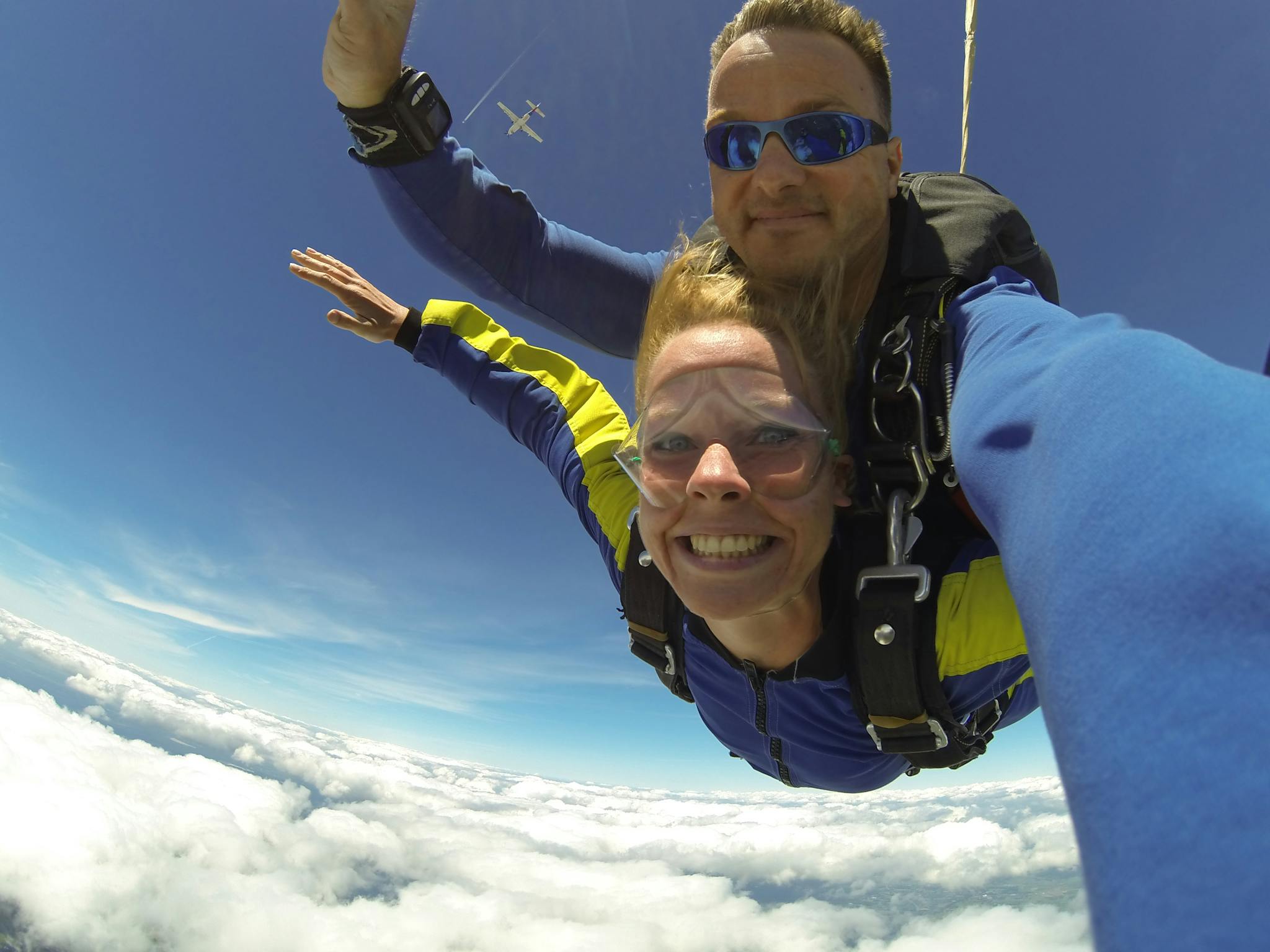 Experience the thrill of tandem skydiving with a breathtaking aerial view above the clouds.
